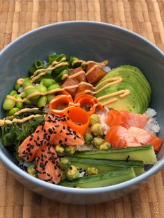 a blue bowl filled with sushi and vegetables