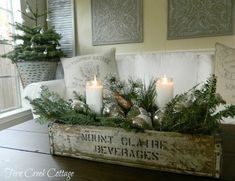 a box filled with candles sitting on top of a wooden table next to a window