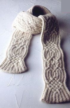 a white knitted scarf laying on top of a table