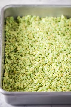 a metal pan filled with green food on top of a counter