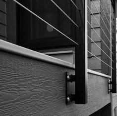 black and white photograph of the side of a house with metal bars on it's windows