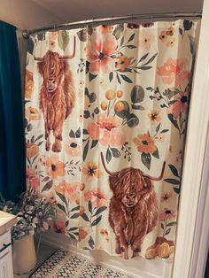 a bathroom with a shower curtain decorated with flowers and an image of a yak