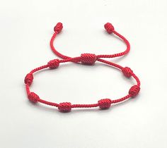 This bracelet is linked to a sequence of 7 Knots, each of which symbolizes a spiritual dimension that ends up infusing your reality. Features: (1) 1.5mm Twisted Nylon Cord (2) Each knot is tightly woven to prevent fraying or becoming loose. (3) Bracelet is made to fit most wrist sizes. Sizes can be customized on request. Handmade Red Bracelets For Blessing, Handmade Red Bracelet For Blessing, Traditional Red Bracelets For Blessing, Symbolic Red Bracelet Jewelry, Red Symbolic Bracelet Jewelry, Symbolic Red Jewelry For Friendship, Elegant Red Adjustable Braided Bracelets, Elegant Red Adjustable Braided Bracelet, Symbolic Red Bracelets As Gift