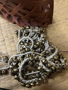 a bunch of bells sitting on top of a woven table cloth next to a basket