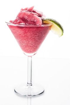 a pink drink with ice and lime garnish