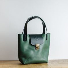 Racing Green Italian Leather Handbag - Hand-stitched with Waxed Cotton Thread.   Designed for daily use, it works for both casual and more formal occasions. Each bag is made from  Italian Veg Tanned Leather and is finished with hand stitched Dark Green 3mm thick veg tan leather handles and with Clasp an antique brass fastener.   This  leather bag is the perfect size for use as an everyday essentials handbag or as a stylish evening purse.   Item Details: * Handmade in Manchester, England * Premiu Leather Handheld Bucket Bag For Everyday Use, Handheld Leather Bucket Bag For Everyday Use, Green Handheld Leather Bag, Everyday Handheld Bags With Leather Lining, Green Soft Leather Satchel For Everyday Use, Green Leather Purse, Everyday Handheld Leather Bucket Bag, Everyday Green Soft Leather Satchel, Green Leather Bucket Bag For Daily Use