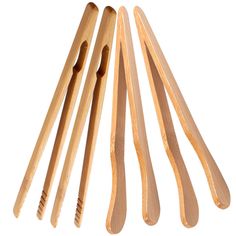 four wooden spoons are lined up on a white surface