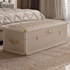 a large white trunk sitting on top of a carpeted floor next to a bed