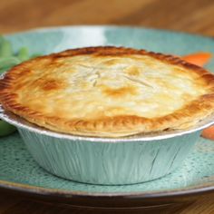 a pie sitting on top of a table next to carrots