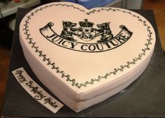 a heart shaped cake with the words juicy couture on it and two stickers