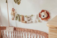 a baby's name sign hanging on the wall next to a basket with stuffed animals