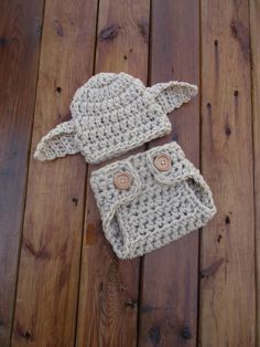 a crocheted hat and diaper cover sitting on top of a wooden floor