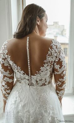 the back of a woman's wedding dress, which is open to reveal an intricate lace design