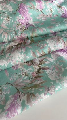 the fabric is green and has pink flowers on it, with purple leaves in the background