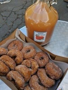 donuts and honey are sitting on a table next to a bottle of orange juice