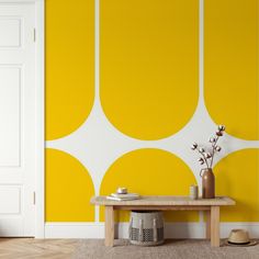 a yellow and white room with a wooden table in front of the wall that has circles painted on it