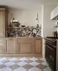 a kitchen with an oven, stove and cabinets in the middle of it's floor