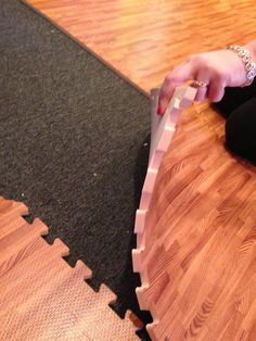 a woman is sitting on the floor with a piece of puzzle