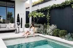 a woman sitting on the edge of a swimming pool