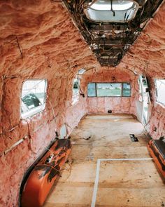 the inside of an airplane that is being renovated with red paint and exposed pipes on the ceiling