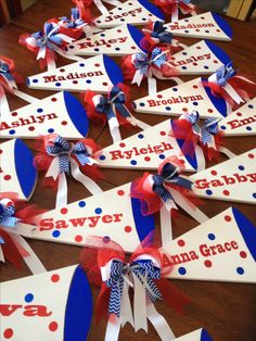 red, white and blue name tags with bows on them are laid out in rows