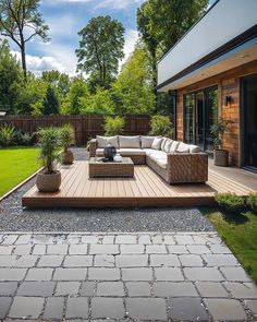 an outdoor living area with couches, tables and potted plants on the deck