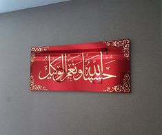 a red sign with arabic writing hanging on the wall