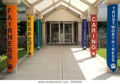 an entrance to a building with colorful banners on the sides and paw prints on the doors