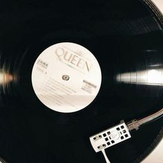 a record player and remote control sitting on top of a black vinyl recordshelf