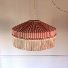 a red and white striped lamp hanging from a ceiling