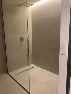 a bathroom with a glass shower door next to a window