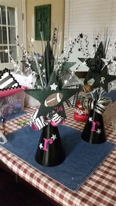 two black and white paper hats on top of a blue table cloth with silver stars