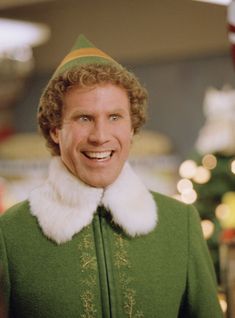 a man dressed in an elf costume smiles at the camera