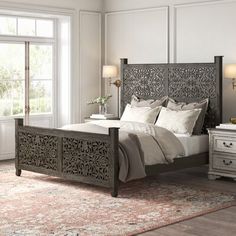 a bedroom with a bed, dresser and two lamps on the side of the room