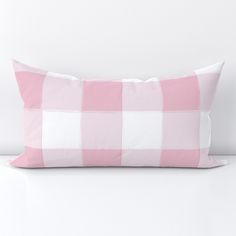 a pink and white checkered pillow sitting on top of a table