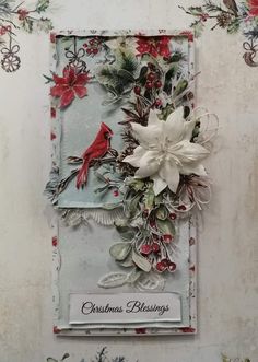 a christmas card with poinsettis, holly and a cardinal on the front