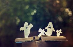 an open book with ghost cutouts sitting on top of it