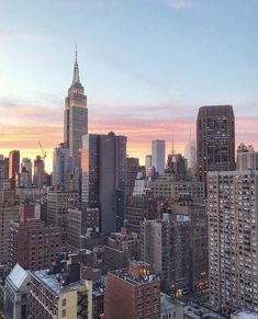 the city skyline is shown at sunset with tall buildings in the foreground and skyscrapers in the background