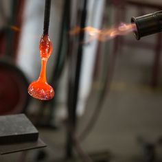 an orange liquid is being poured onto a metal surface with a pipe in the background