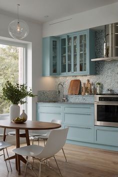 a kitchen with blue cabinets and white chairs