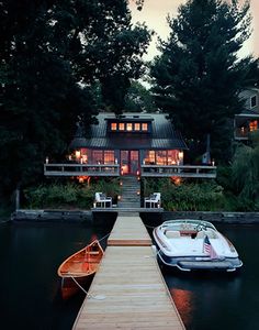 a boat is docked at the end of a dock with a house in the background