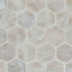 a tile floor with hexagonal tiles on the top and bottom, in light grey tones