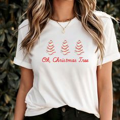 This Christmas Tree Cake Holiday T-Shirt exudes festive vibes, perfect for the holiday season. Made from soft and durable ring-spun cotton, this unisex t-shirt offers comfort all year round. The classic fit and crew neckline make it versatile for any occasion, whether formal or semi-formal. Ideal for holiday parties and celebrations. Product features - Made from 100% ring-spun cotton for a lightweight feel - Classic fit with crew neckline for versatile style - Ethically grown and harvested US co Festive White T-shirt With Letter Print, Festive White Crew Neck T-shirt, White Crew Neck T-shirt For Festive Occasions, Winter Celebration, Tree Cake, Christmas Tree Cake, Tree Cakes, Xmas Shirts, Holiday Cakes