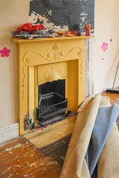 a living room with a fire place and couches in front of an easel