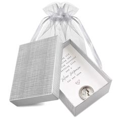 an open gift box with a silver coin inside and a white ribbon around the top