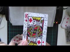 a person holding up a playing card in their hand