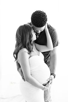 a black and white photo of a pregnant couple