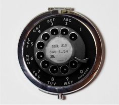 an old fashioned phone with numbers and dials on the front, sitting against a white background