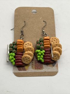 a pair of earrings made out of crackers and vegetables