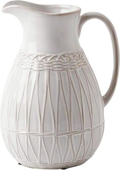 a white ceramic pitcher with wavy lines on the bottom and sides, sitting on a white background